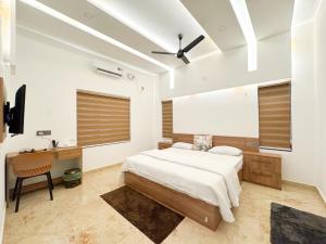 a bedroom with a bed and a desk in it at CRK Home Stays in Cochin +40 photos
