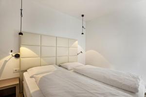 a bedroom with two beds with white sheets at Apartment Dui Residence Bun Ste in San Vigilio Di Marebbe