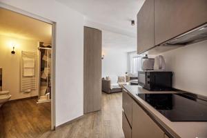 a kitchen with a microwave and a living room at Apartment Dui Residence Bun Ste in San Vigilio Di Marebbe