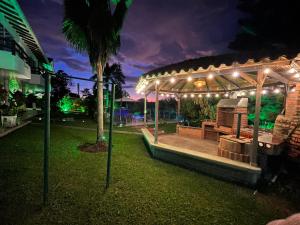 a gazebo with a bench in a park at night at Villa Edén Alto in La Tebaida