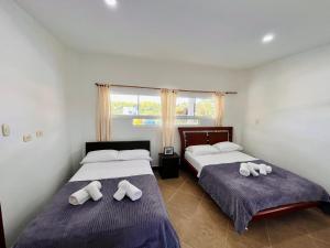 two beds in a bedroom with towels on them at Villa Edén Alto in La Tebaida +25 photos