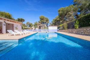 a swimming pool with chairs and a house at Romántica Jávea -Solo Familias 1769 in El Tosalet