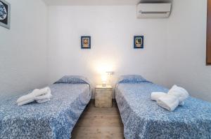 two beds in a room with blue sheets and towels at Romántica Jávea -Solo Familias 1769 in El Tosalet +16 photos