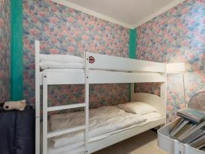 a bedroom with two bunk beds with floral wallpaper at Maison de la plage in Valras-Plage