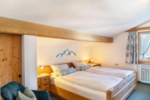 a bedroom with a large bed with a wooden headboard at Ferienwohnungen Arnspitz in Krün in Krün