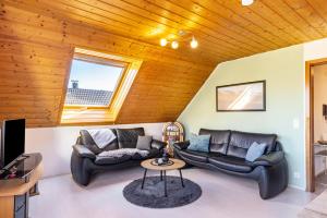 a living room with two leather couches and a tv at Ferienwohnung Sonnenblick in Albstadt