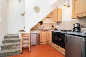 a kitchen with a staircase leading up to a stair case at Etnalodge in Piedimonte Etneo +16 photos