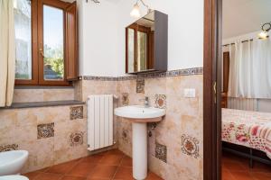 a bathroom with a sink and a bed at Etnalodge in Piedimonte Etneo