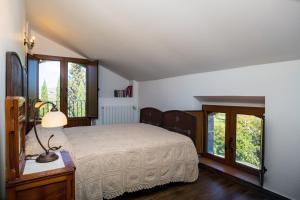 a bedroom with a bed in a room with windows at Etnalodge in Piedimonte Etneo