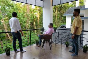 a group of three people playing a video game on a balcony at CRK Home Stays in Cochin