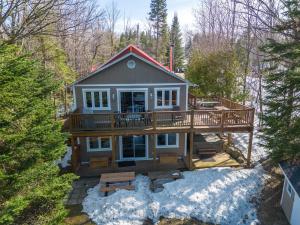 a large house with a deck in the woods at Rustic & Charming Mont Blanc Chalet Private Spa in Saint-Faustin