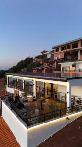 a building with a balcony with chairs and tables at Hotel Kappa3 Villas in Vlorë