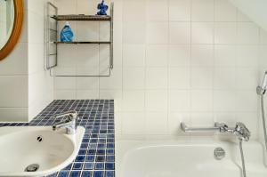 a bathroom with a tub and a sink at Fewo3 Buppeape Saterland in Bollingen +23 photos