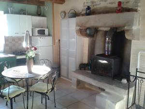 a kitchen with a stove and a table and chairs at Le Courtil De Bourrien in Languédias