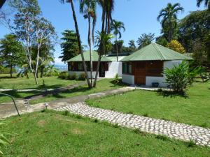 a house with a garden and a grass yard at Corcovado Beach Lodge in Puerto Jiménez