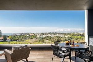 a dining room with a table and chairs and a large window at Luxury T2 Apartment With Ocean View in Portimão