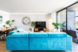 a living room with a blue couch at Luxury T2 Apartment With Ocean View in Portimão