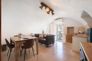 a kitchen and living room with a table and a couch at Casa Tuccia in Ostuni