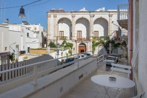 a balcony with a table and a view of a building at Casa Tuccia in Ostuni