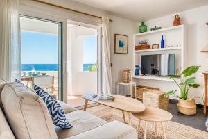 a living room with a couch and a table at Binibeca Sunset in Sant Lluis