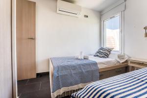 two beds in a room with a window at Binibeca Sunset in Sant Lluis +18 photos