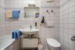 a bathroom with a sink and a toilet and a tub at Fewo Brünnstein - Nr 40 Pool, Sauna in Oberaudorf +9 photos