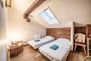a bedroom with two beds and a skylight at Chalet Triplex avec Piscine - Sauna in Samoëns +31 photos