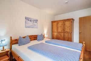 a bedroom with a bed with blue and white sheets at Fewo Brünnstein - Nr 40 Pool, Sauna in Oberaudorf