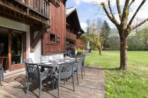 a wooden deck with a table and chairs at Chalet Triplex avec Piscine - Sauna in Samoëns