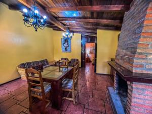 a dining room with a table and a fireplace at Villas Lupita in Mazamitla