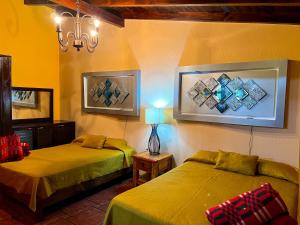 a bedroom with two beds and a lamp and a mirror at Villas Lupita in Mazamitla