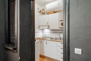 a small kitchen with white cabinets and a sink at Conde Center Premium Suites in Seville