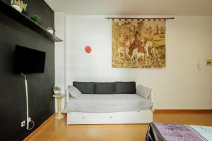 a living room with a couch and a painting on the wall at Conde Center Premium Suites in Seville