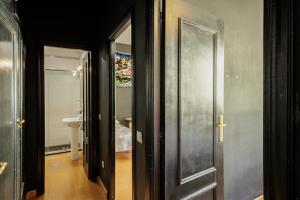 a hallway with a door leading to a bathroom at Conde Center Premium Suites in Seville +21 photos