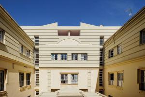 a large white building with windows in a courtyard at Conde Center Premium Suites in Seville