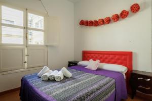 a bedroom with two beds with white and purple sheets at Conde Center Premium Suites in Seville