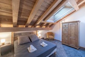 a bedroom with a bed and a wooden ceiling at Albert le Cerf in Morillon