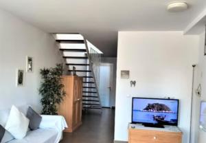 a living room with a white couch and a staircase at Duplex Mediterranea in Benicarló
