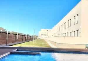 a swimming pool in front of a building at Duplex Mediterranea in Benicarló