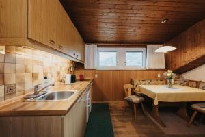 a small kitchen with a sink and a table at Unterhauserhof App B in Valdaora
