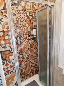 a shower in a bathroom with mosaic tiles on the wall at Valepiace 1 in Piacenza
