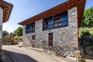 a stone house with a balcony on the side of it at Orandi in Cangas de Onís