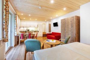 a room with a bed and a table and a kitchen at Glöcklehof in Todtnau