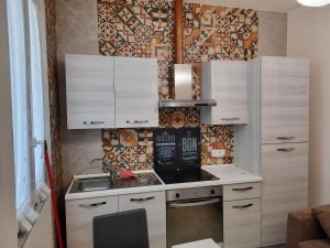 a small kitchen with white cabinets and a stove at Valepiace 1 in Piacenza
