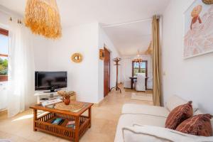 a living room with a couch and a tv at Oasis del Sol in Llombarts