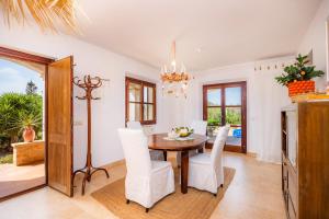 a dining room with a table and white chairs at Oasis del Sol in Llombarts