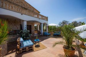 a patio of a house with blue chairs and plants at Oasis del Sol in Llombarts