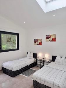 a white room with two beds and a window at La maison Arkéa Aréna est climatisée avec ménage, draps et serviettes inclus in Floirac