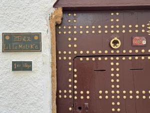 a brown door with gold balls on the side of a building at Dar lalla Malika in Rabat