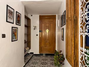 a hallway with a wooden door and a tile floor at Dar lalla Malika in Rabat